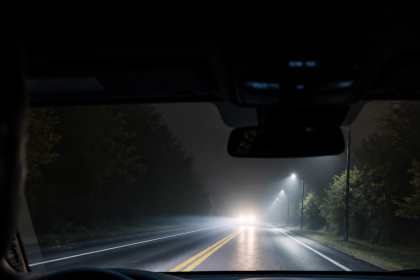 Car thermal night vision system displaying a pedestrian and vehicle on a dark road