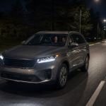 Family car driving on a well-lit road at night