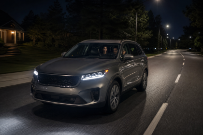 Family car driving on a well-lit road at night