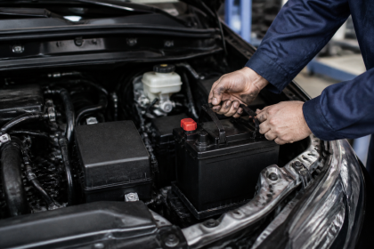 Car battery installed under the hood of a vehicle
