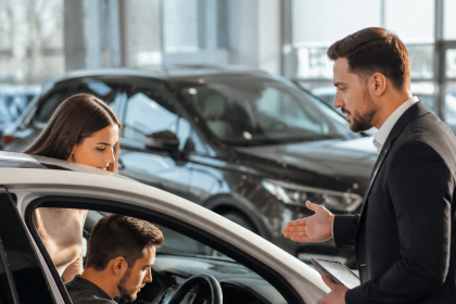 Buyer inspecting a used car to decide if it is worth buying