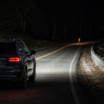 Automotive thermal night vision display highlighting a pedestrian on a dark road