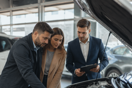 Buyer inspecting a used car with a checklist before purchase